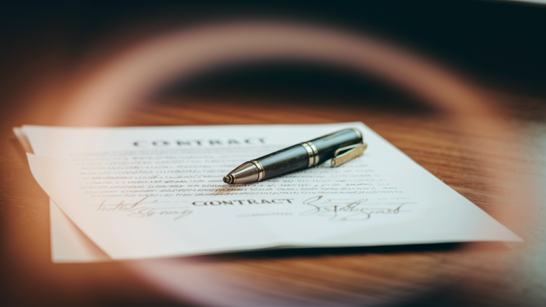 A signed contract agreement on a wooden desk, with a high-end quality pen resting on the paper.