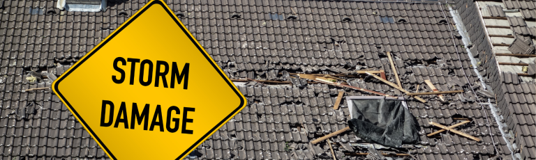 roof with damage and yellow sign saying storm damage